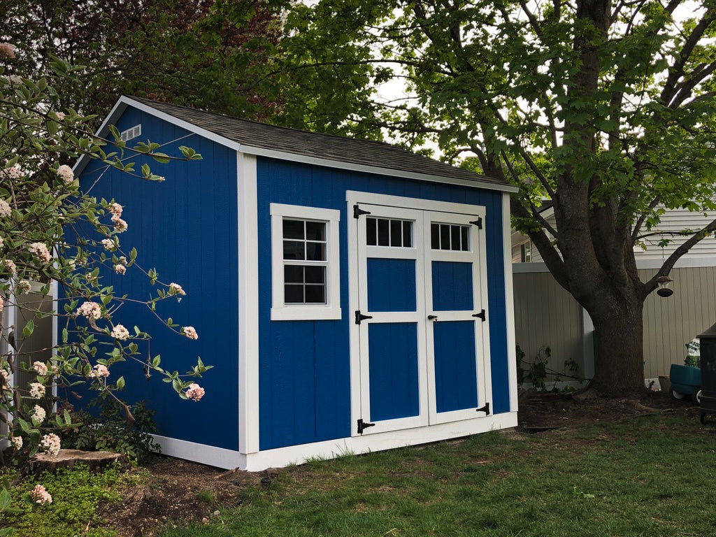 Custom blue shed with white trim and single window.